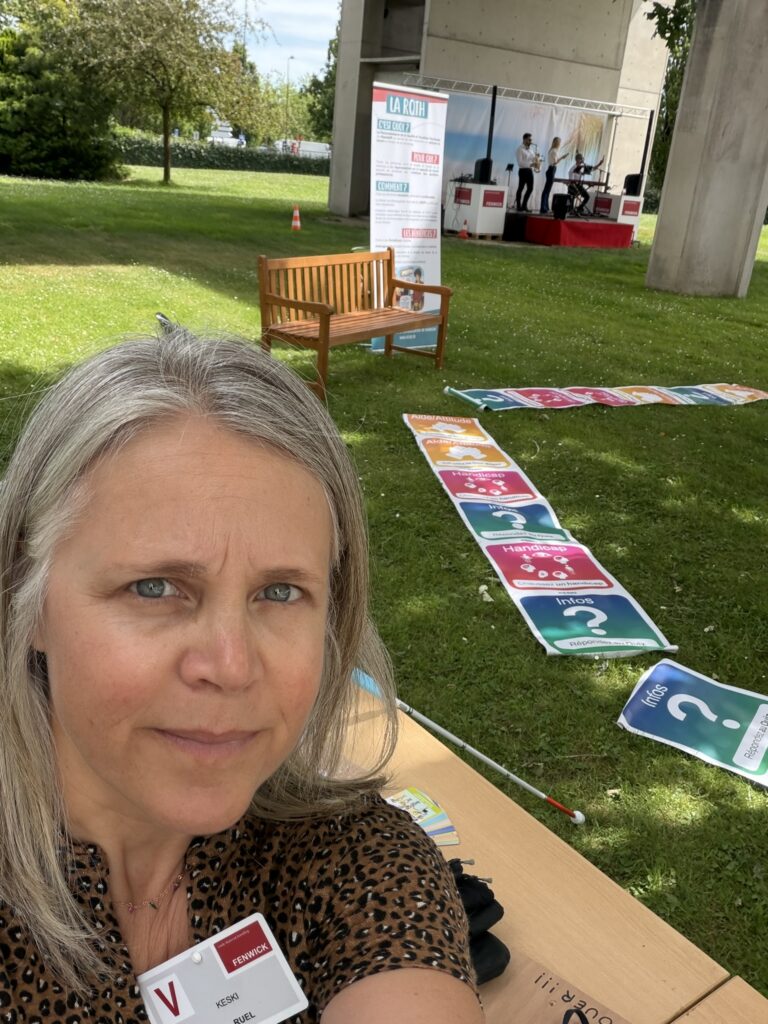 Anne-Laure de KESKI devant le Jeu Géant Handicap installé dans l'herbe à l'occasion de la journée estivale d'une grande entreprise
